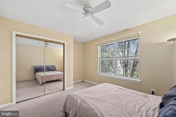 a bedroom with a bed and a large window