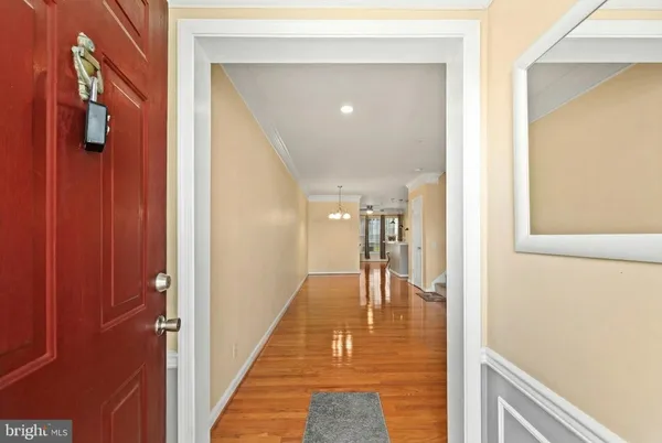 a hallway with wooden floor and staircase