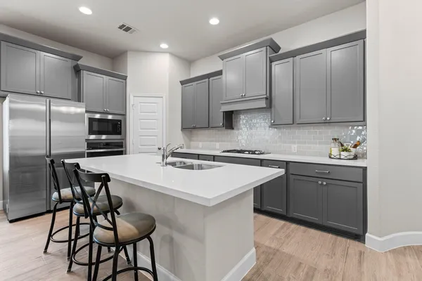 a kitchen with kitchen island a counter top space cabinets and stainless steel appliances