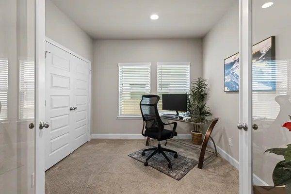 a view of a workspace with furniture and a window