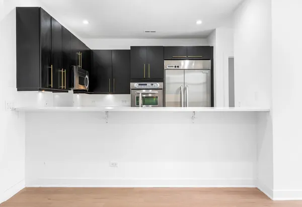 a view of a kitchen with a refrigerator and a sink