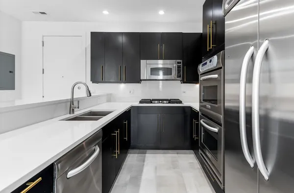 a kitchen with kitchen island stainless steel appliances a sink stove and refrigerator