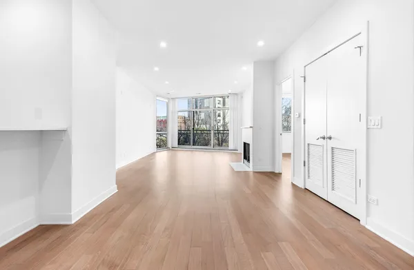 a view of a big room with wooden floor and windows