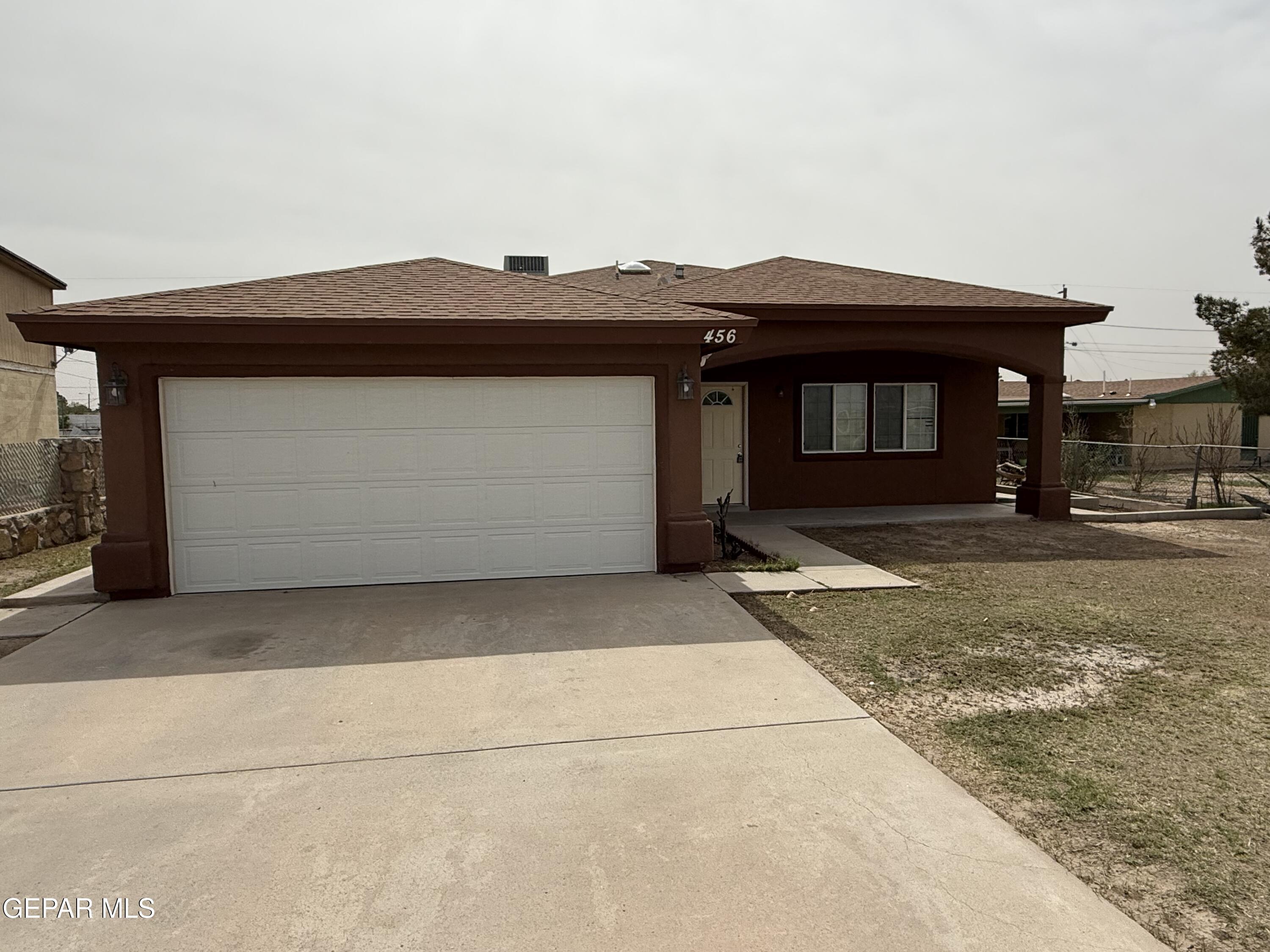 456 Passmore Road Socorro, TX 79927 - Photo 2 of 23 a front view of a house with a yard and garage
