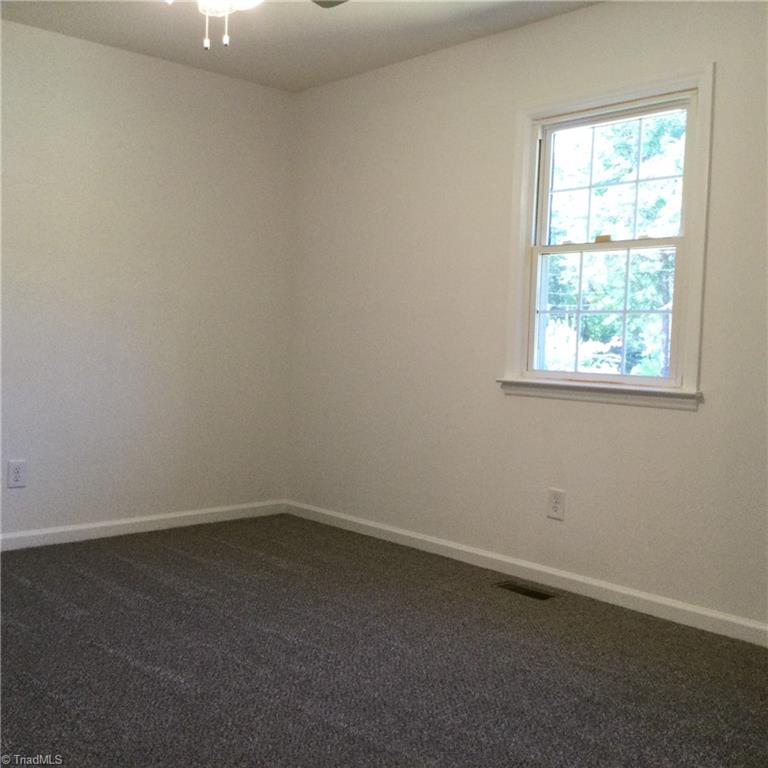 1017 Sales Street High Point, NC 27260 - Photo 20 of 40 Primary Bedroom: Features include carpet flooring to help keep you warm on cool mornings, a window for natural lighting, fresh new paint and a ceiling fan with light.