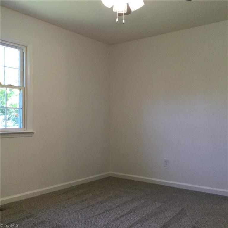 1017 Sales Street High Point, NC 27260 - Photo 21 of 40 Primary Bedroom: Features include carpet flooring to help keep you warm on cool mornings, a window for natural lighting, fresh new paint and a ceiling fan with light.
