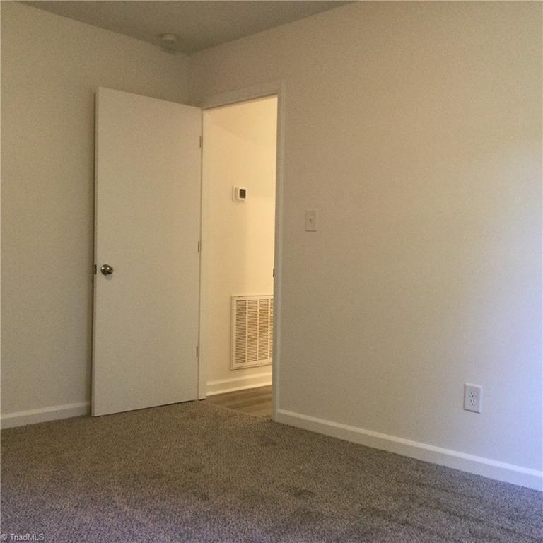 1017 Sales Street High Point, NC 27260 - Photo 28 of 40 Bedroom 2: Fearures include carpet flooring to help keep you warm on cool mornings, fresh new paint and a window for natural lighting. The entry door is shown to the far end.