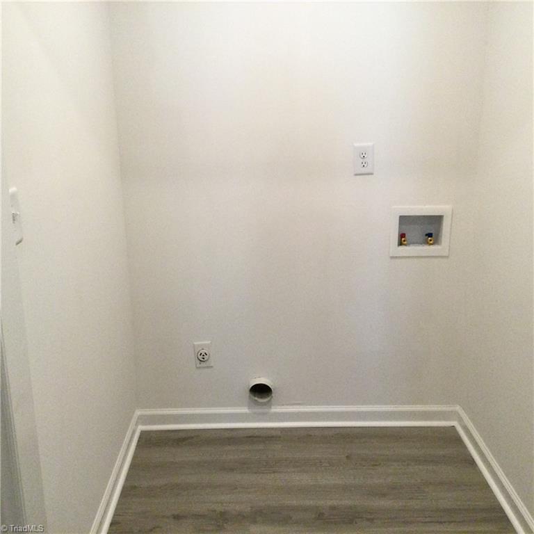 1017 Sales Street High Point, NC 27260 - Photo 34 of 40 Main Hall Bathroom - Laundry Room: Here we can see that you have all the needed hookups for your washer and dryer. You have vinyl plank flooring for easy cleaning and fresh new paint and an overhead light.