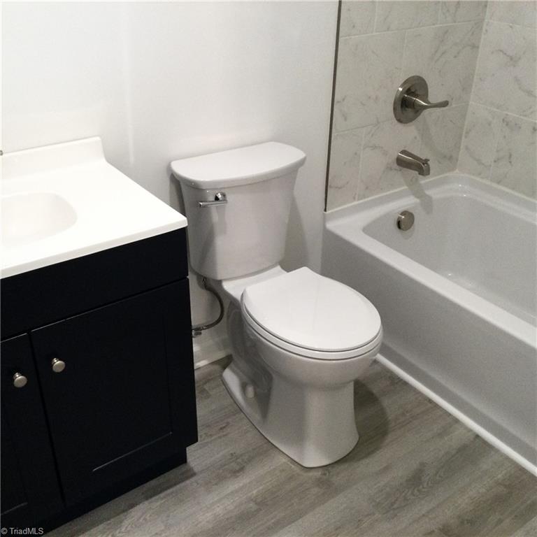 Primary En-Suite Bathroom: Features include vinyl plank flooring for easy cleaning, fresh new paint and a decorative vanity with new fixtures. You also have the tub/shower unit with decorative wall covering.