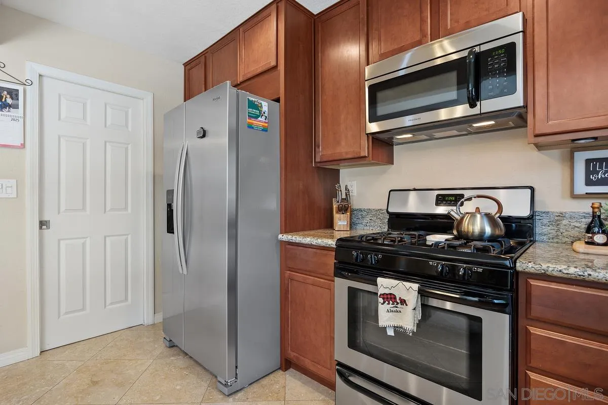 13961 Eastern Street Poway, CA 92064 - Photo 11 of 29 a kitchen with stainless steel appliances granite countertop a stove and a microwave
