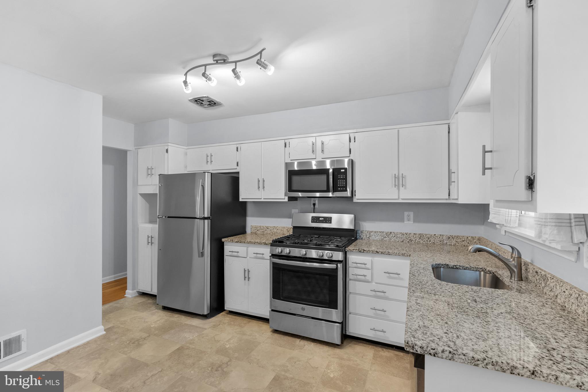 1201 Chillum Manor Road Hyattsville, MD 20783 - Photo 18 of 49 a kitchen with refrigerator a microwave and cabinets