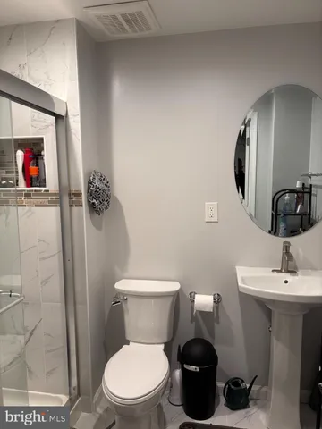 a bathroom with a toilet a sink and mirror