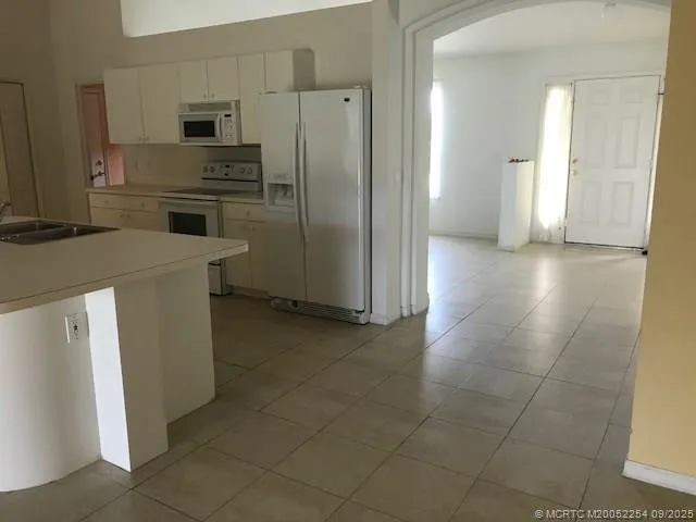 a kitchen with a refrigerator and a stove top oven