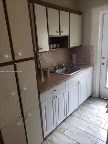 a kitchen with a sink a refrigerator and cabinets