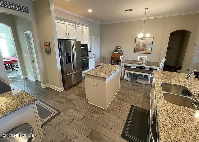 a kitchen with stainless steel appliances granite countertop a refrigerator stove and sink