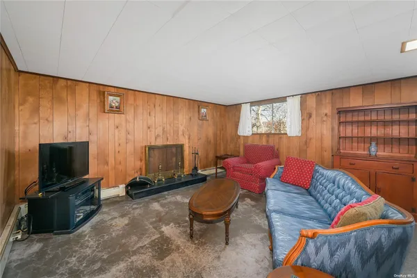 a living room with furniture a flat screen tv and a window