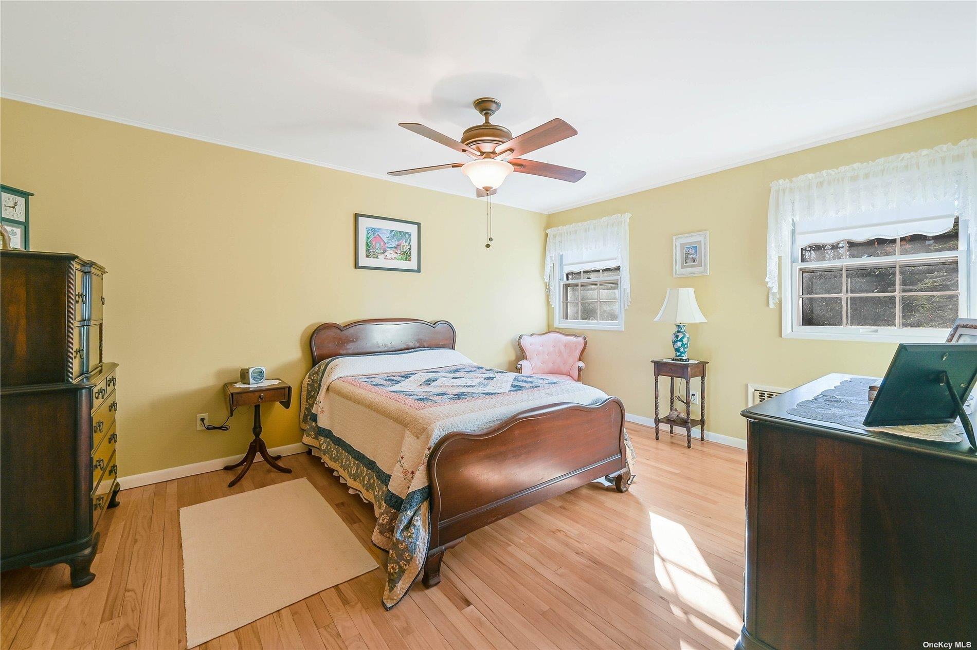 415 Southern Cross Road Cutchogue, NY 11935 - Photo 9 of 14 a bedroom with a bed and wooden floor