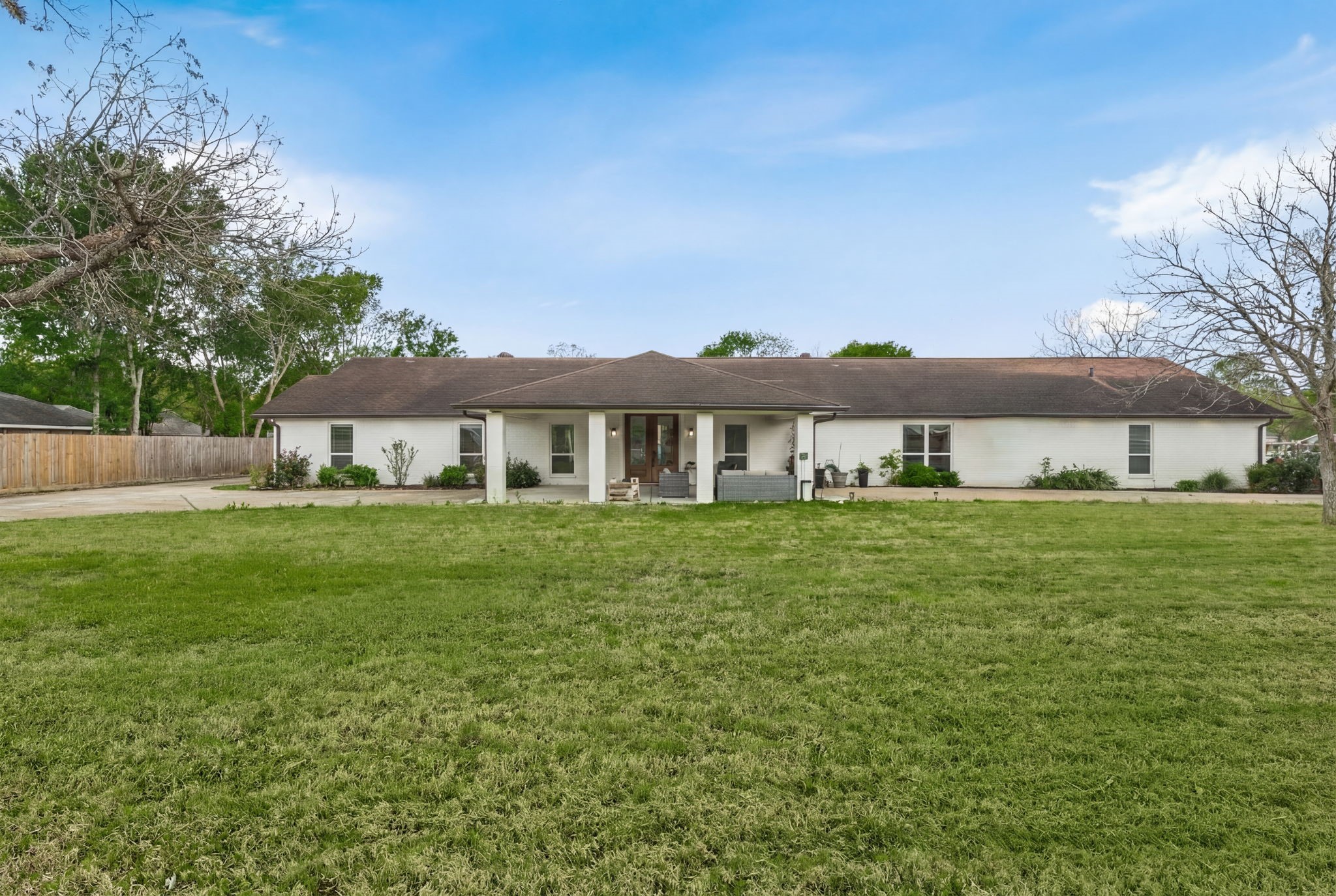 Welcome to 8800 Brae Acres - A stunning ranch style home set on just over an acre.  A bright white brick facade stretches across a deep front yard framed by mature trees surrounding the home and a centered covered front porch anchors the facade.