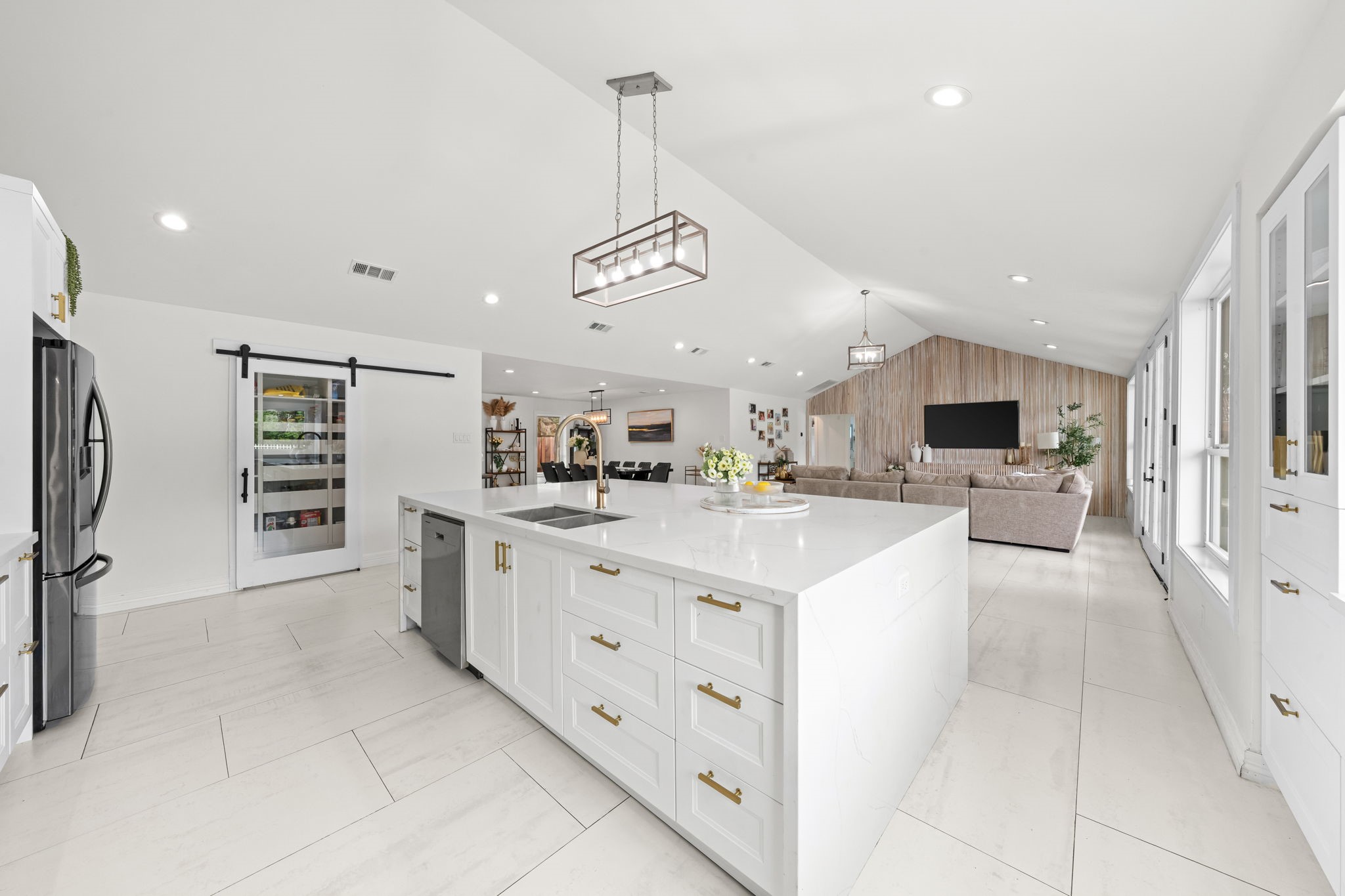 8800 Brae Acres Road Houston, TX 77074 - Photo 12 of 48 A sliding barn door on the wall adjacent to the island opens to the walk-in pantry — substantial dry storage directly in the cooking zone without the footprint of a dedicated room.