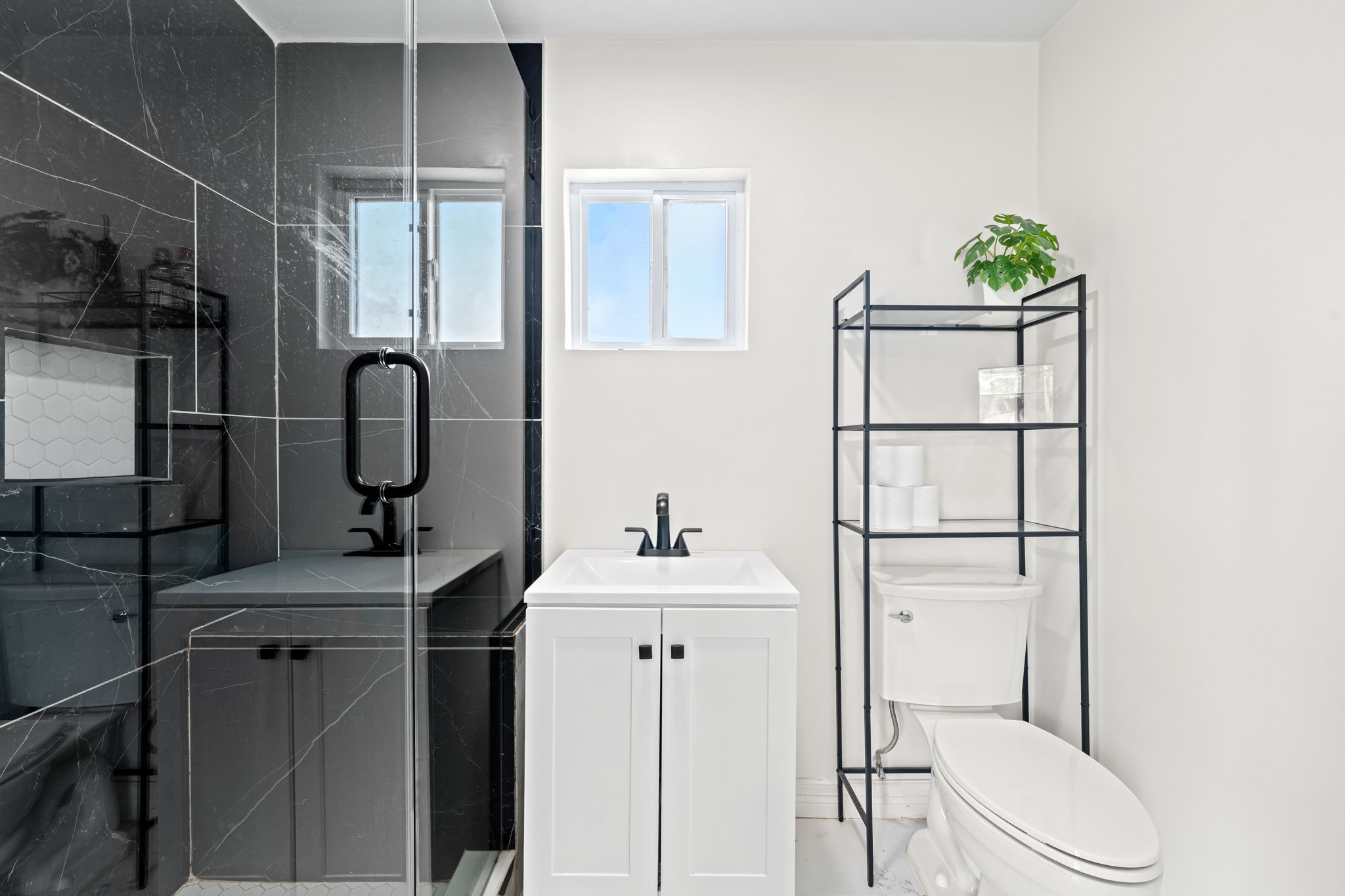 8800 Brae Acres Road Houston, TX 77074 - Photo 31 of 48 The bedroom's en-suite bath offers large black veined tile in an all glass walk-in shower, single vanity with black hardware, and ample lighting.