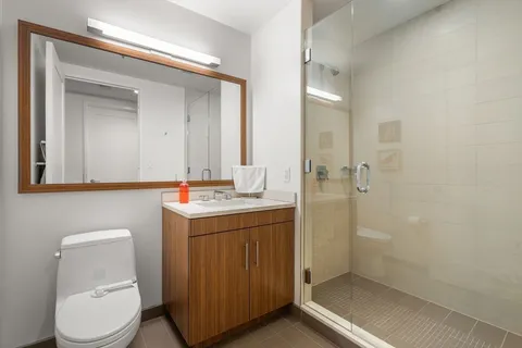 a bathroom with a granite countertop sink toilet and shower