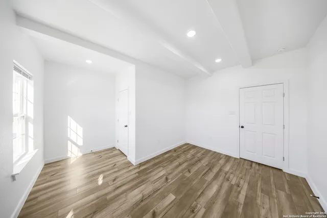 a view of a room with wooden floor and white walls