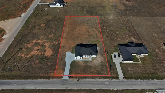 an aerial view of a house with a yard