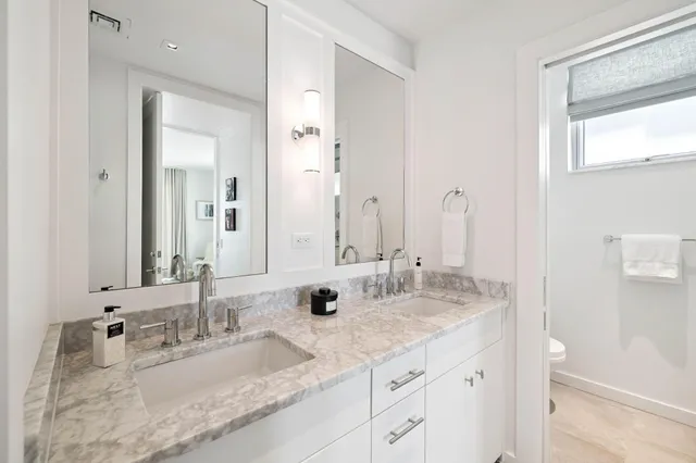 a bathroom with double sink and a mirror
