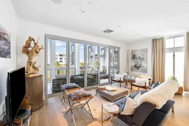 a living room with furniture a flat screen tv and a floor to ceiling window