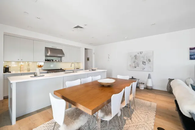 a kitchen with a dining table chairs and a refrigerator
