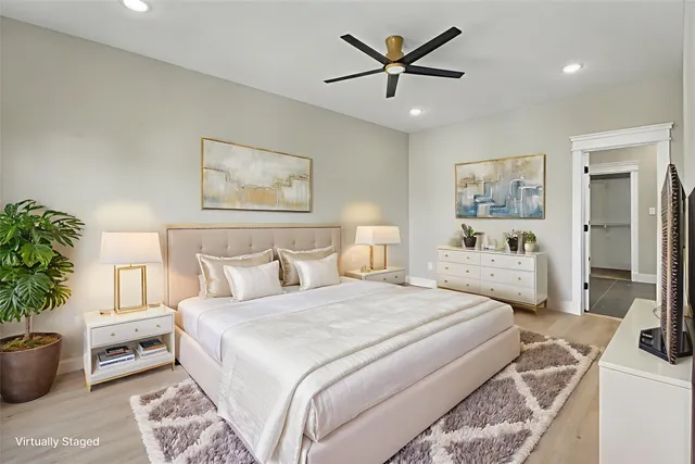 a spacious bedroom with a bed a couch and a potted plant