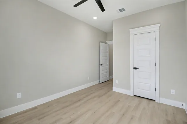 an empty room with wooden floor and closet