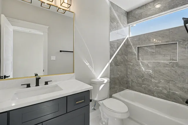 a bathroom with a sink a toilet and a large mirror