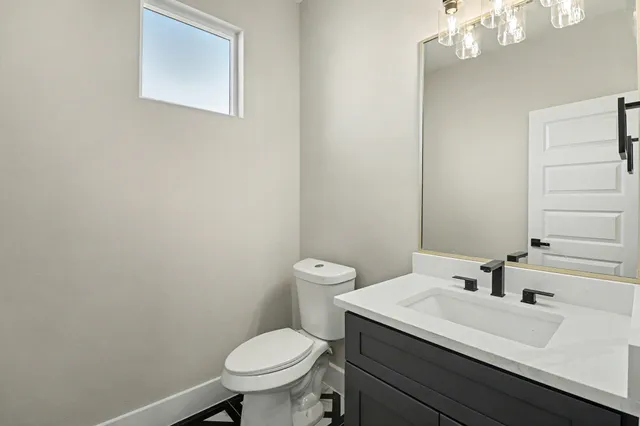 a bathroom with a sink a toilet and a mirror