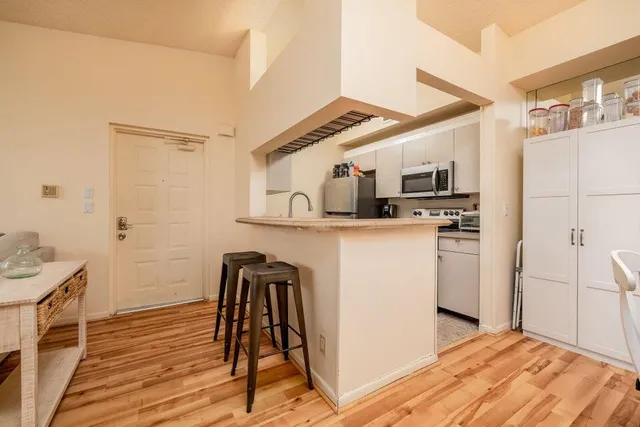 a kitchen with stainless steel appliances kitchen island granite countertop a refrigerator a stove top oven a sink and dishwasher