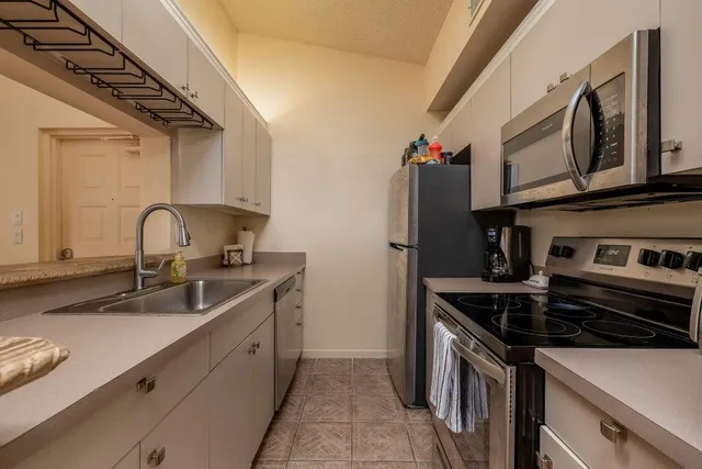 a kitchen with stainless steel appliances a sink and cabinets