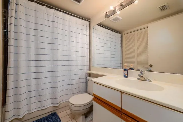 a bathroom with a sink mirror vanity and toilet