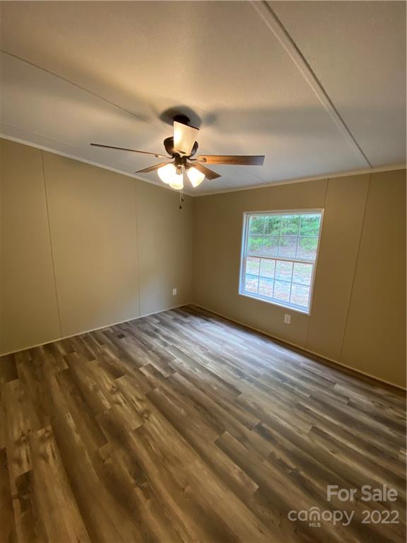 7109 Rushing Road Peachland, NC 28133 - Photo 26 of 40 an empty room with a chandelier fan and windows