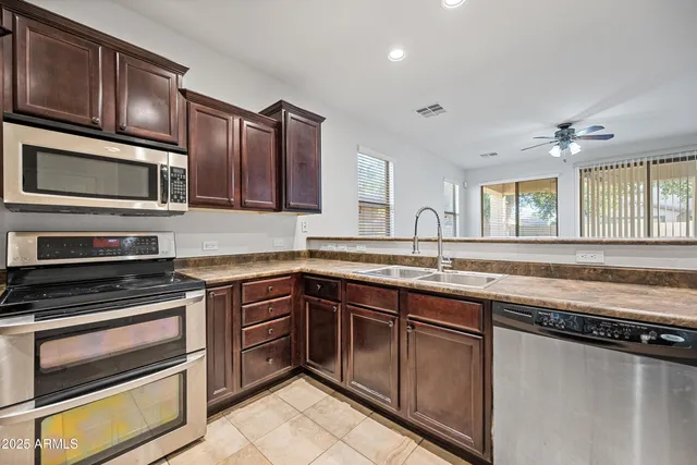 a kitchen with stainless steel appliances granite countertop a stove microwave and cabinets