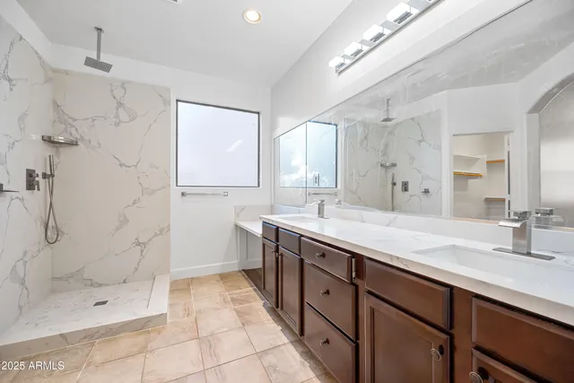 a spacious bathroom with a shower sink and mirror