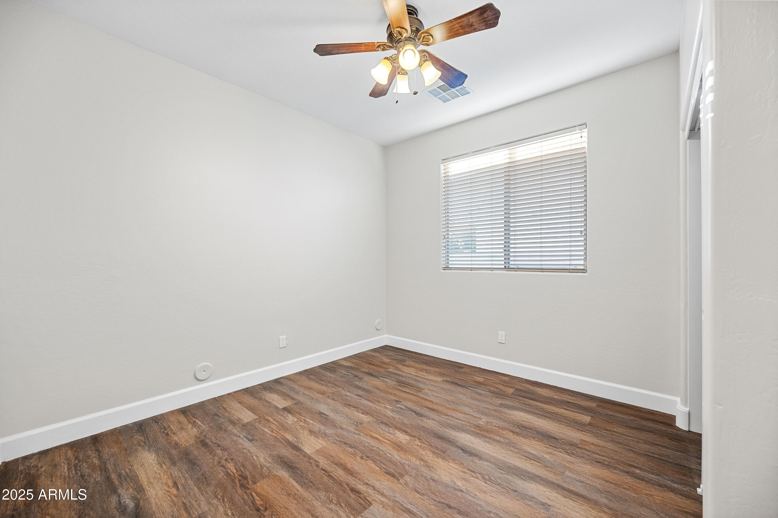 10805 West Woodland Avenue Avondale, AZ 85323 - Photo 19 of 25 wooden floor in an empty room with a window