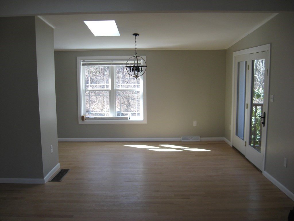 5 Old Amherst Road, Unit 5B Belchertown, MA 01007 - Photo 30 of 37 a view of an empty room with wooden floor and a window
