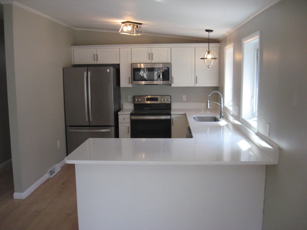 5 Old Amherst Road, Unit 5B Belchertown, MA 01007 - Photo 6 of 37 a kitchen with stainless steel appliances granite countertop a sink and a refrigerator