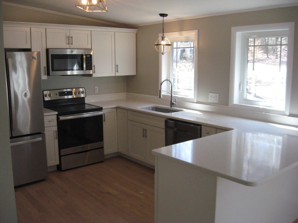 5 Old Amherst Road, Unit 5B Belchertown, MA 01007 - Photo 7 of 37 a kitchen with stainless steel appliances granite countertop a sink stove microwave and refrigerator
