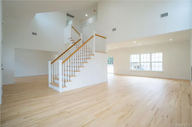 a view of a big room with wooden floor and windows