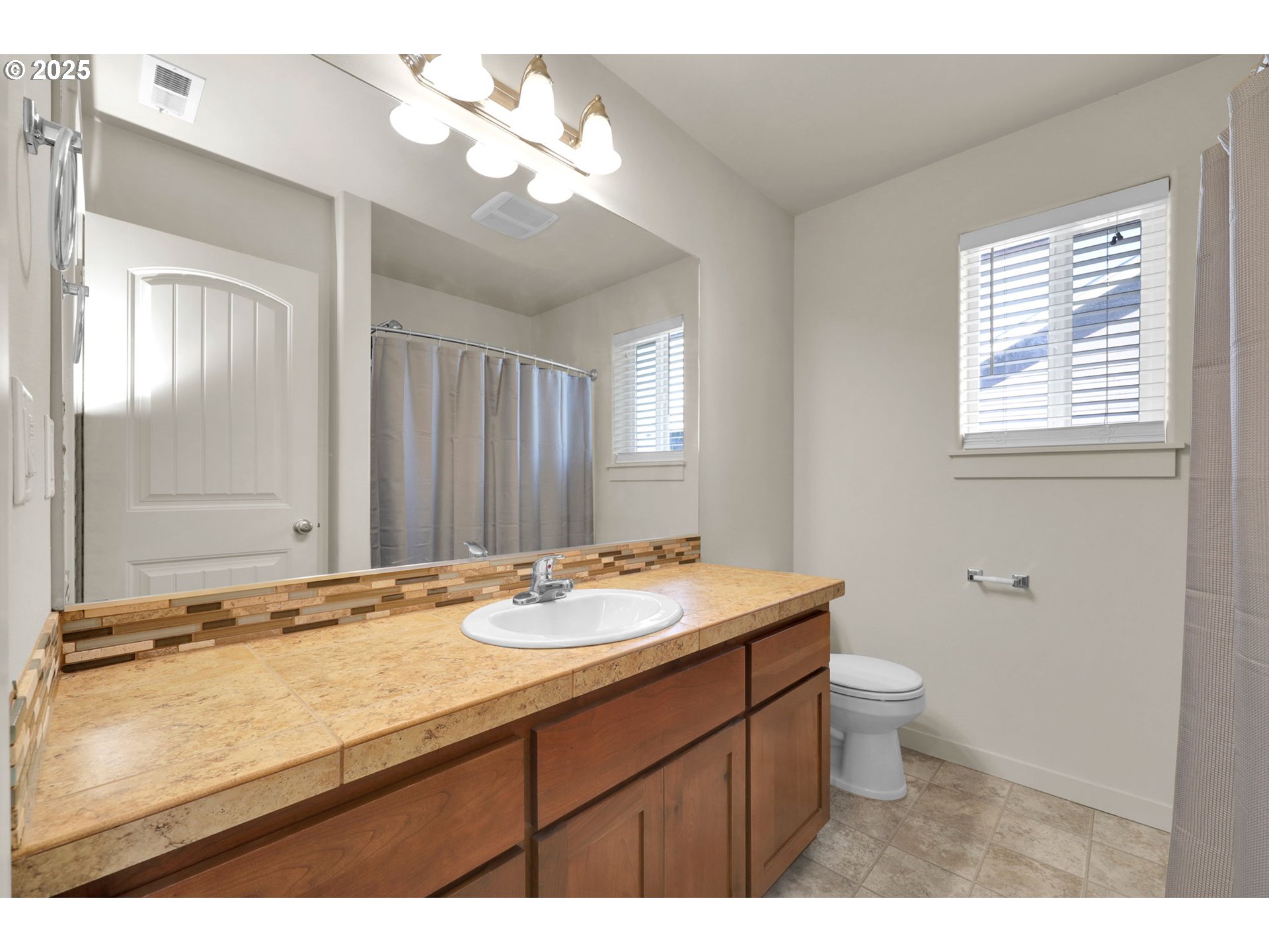 490 Raber Road Eugene, OR 97402 - Photo 20 of 37 a bathroom with a granite countertop sink toilet a large mirror and shower