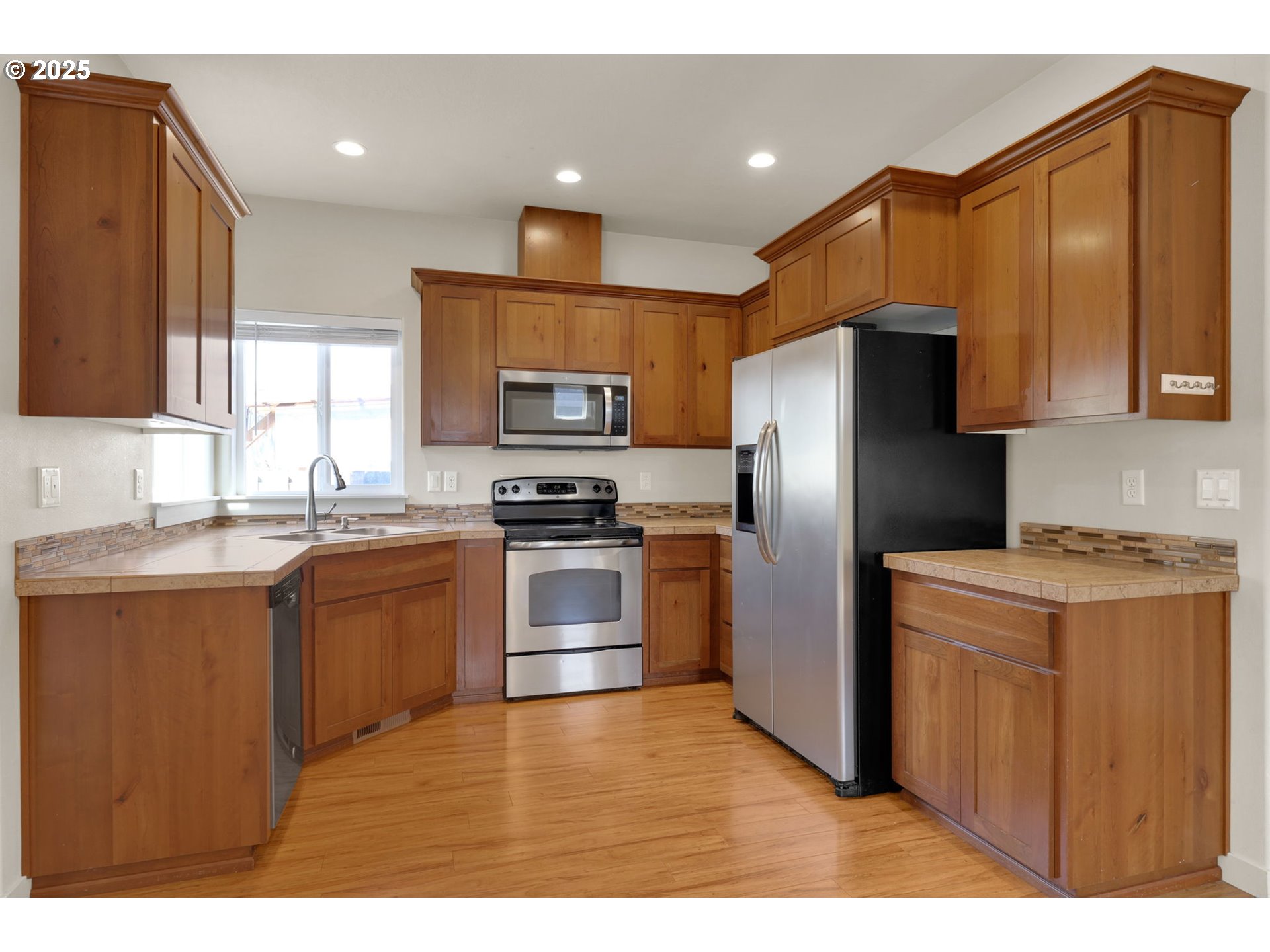490 Raber Road Eugene, OR 97402 - Photo 5 of 37 a kitchen with stainless steel appliances a refrigerator a stove a sink cabinets and a counter top space