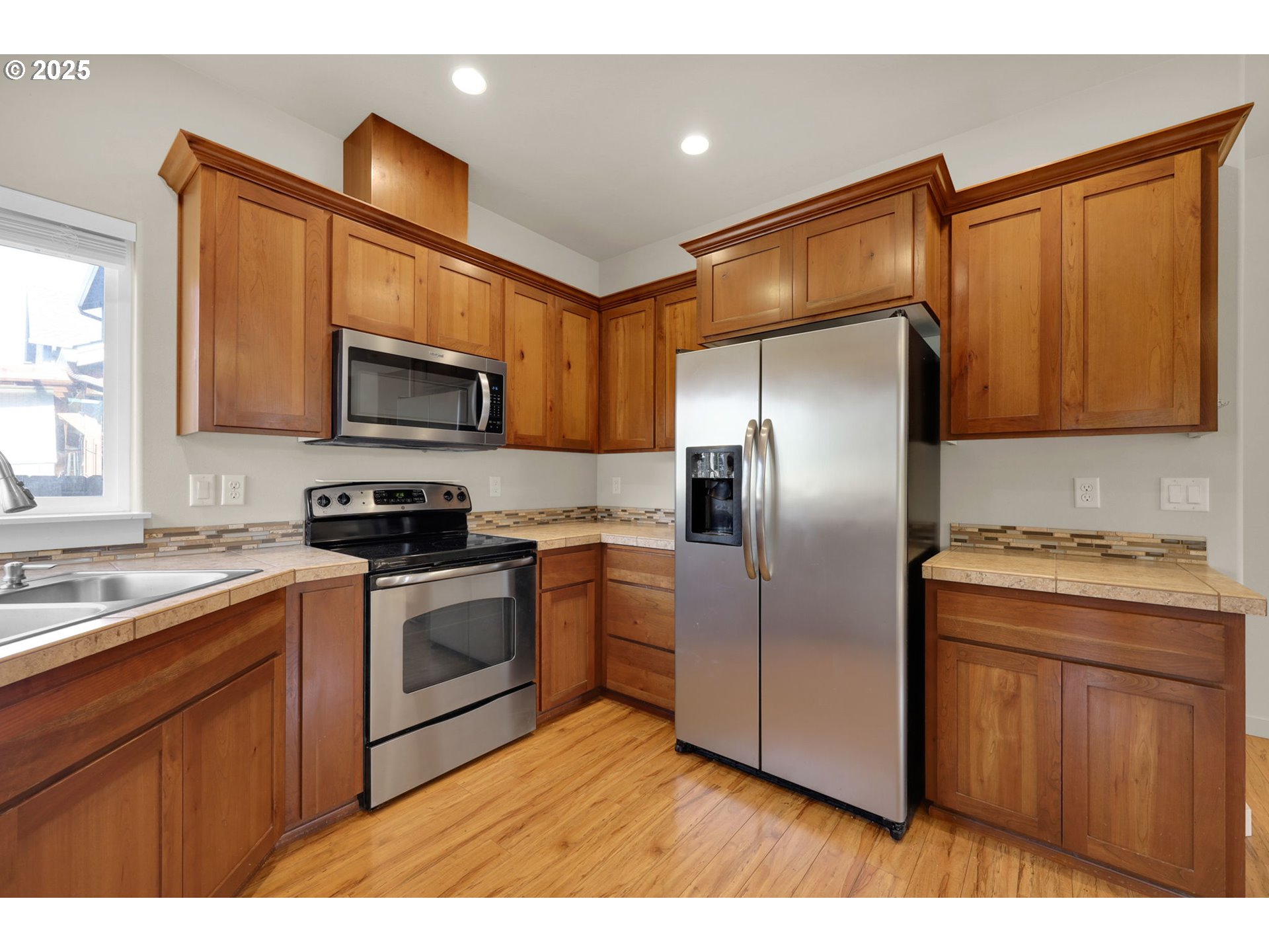 490 Raber Road Eugene, OR 97402 - Photo 6 of 37 a kitchen with kitchen island a counter top space cabinets stainless steel appliances and a window