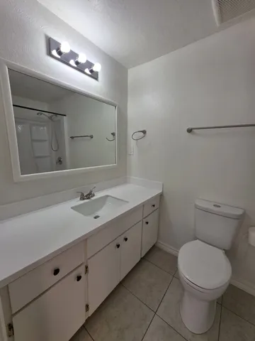 a bathroom with a toilet a sink and mirror