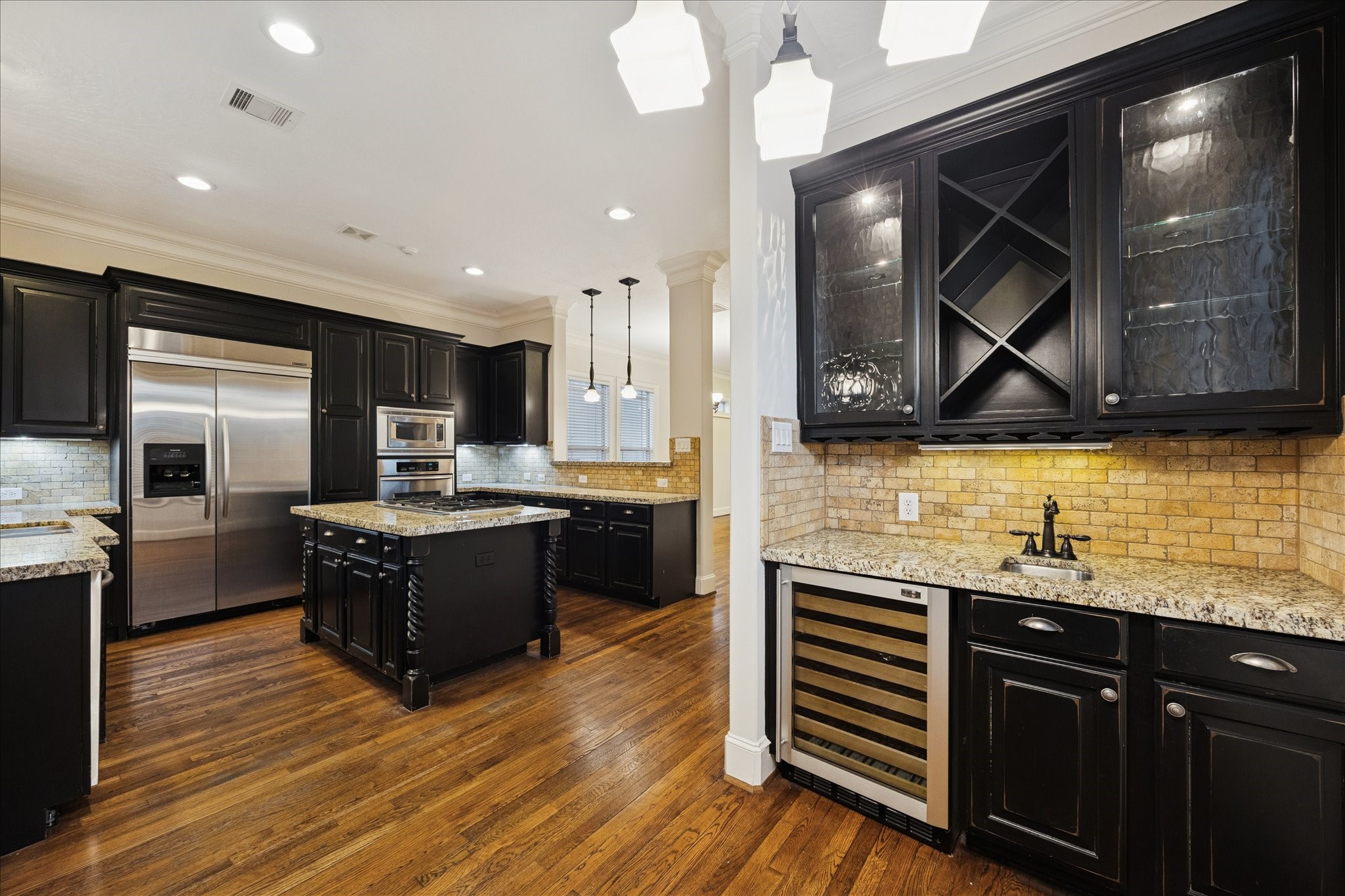 840 Alexander Street Houston, TX 77007 - Photo 15 of 39 This spacious kitchen features elegant custom wood cabinetry, granite countertops, a central island, stainless steel Kitchen aid appliances included, and a wine cooler. The hardwood floors and ample lighting create a warm and inviting atmosphere.